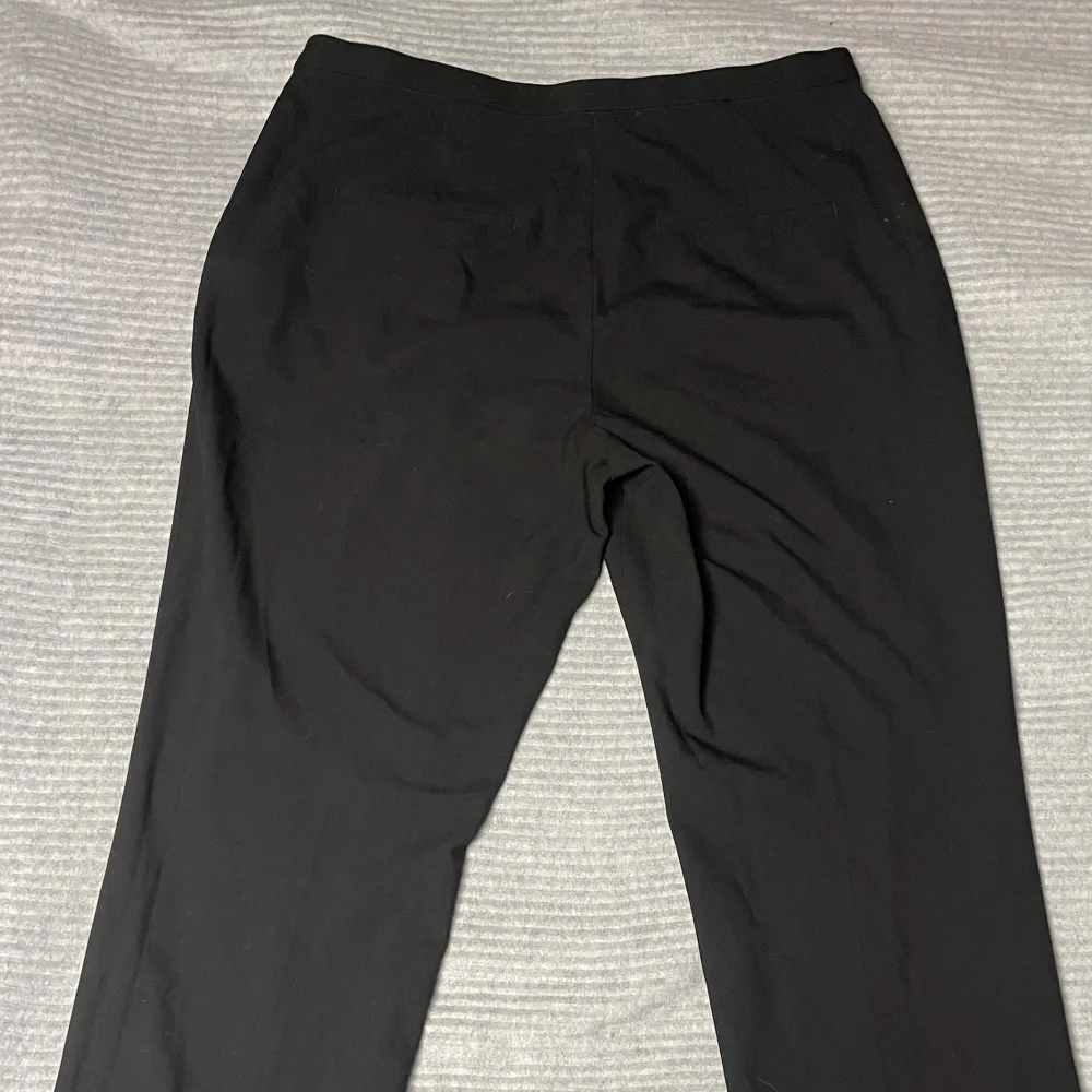 Snygga svarta kostymbyxor från H&M med en klassisk passform. Perfekta för en stilren look. Tillverkade i ett bekvämt material som passar för olika tillfällen.. Farkut & Housut.