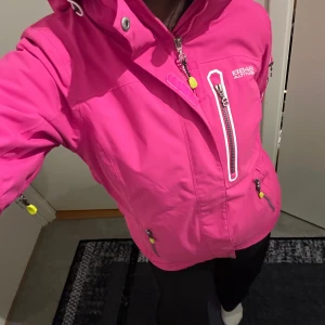 Rosa jacka från 8848 Altitude - Rosa jacka från 8848. Mycket fint skick sparsamt använd. Flera innefickor och även två fickor för eventuella liftkort, en vid armen och en bröstficka. Luvan är avtagbar. Har även en matchande mössa som man kan få med gratis om man vill det.