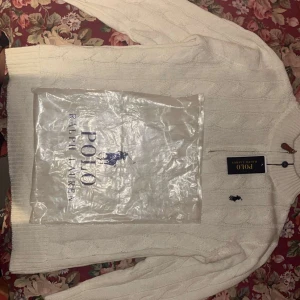 Vit stickad tröja från Ralph Lauren - Säljer en stilren vit stickad tröja från Ralph Lauren. Knappt använd fick den i julklapp, lite för stor för mig