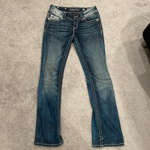 Utsvängda lågmidjade Miss Me jeans - SÅLDA! Snygga mörkblåa Miss Me jeans jag ska sälja för de är lite stora för mig💕 Jättebra skick och använda några gånger, har liten fläck vid knävecket, skickar bilder privat, men syns knappt och går att tvätta bort. Midjemått: 35,5 cm Innerbenslängd: 82,5 cm.  Kontakta vid köp. Kontakta även för mer bilder, köparen står för frakten.