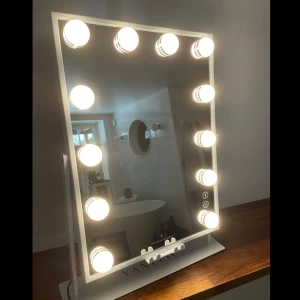 Lyxig sminkspegel  - Lyxig sminkspegel med mycket bra ljus, det är dimbart med tre ljuslägen; kallt, neutralt o varmt. Spegeln kan vinklas som man vill ha den. En mini spegel i 10x medföljer. Finns ett ställ där man trådlöst kan ladda mobilen på spegeln, då kan man tex kolla på film när man sminkar sig. Finns även inbyggd högtalare som man enkelt kopplar till med bluetooth. Spegelmått: 30x41cm, med stativet blir den 48cm hög. Den är helt ny, oanvänd, originalfärpackning finns. Nypris 800kr. Köpare står för frakt!❤️