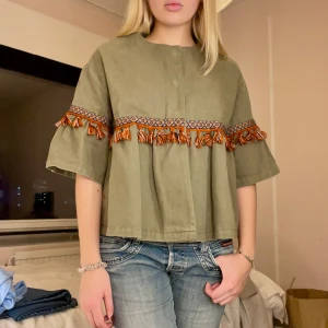 Grön trekvartsärmad jacka  - Grön trekvartsärmad jeans jacka med detaljer med tofsar i olika färger från Zara