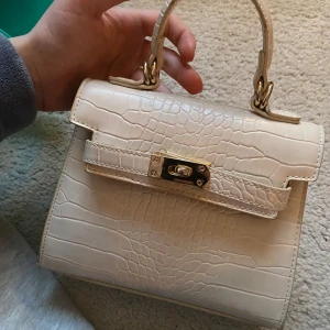 Beige handväska från Gina Tricot - Fin liten beige handväska från Gina Tricot. Aldrig använd så mycket  bra skick😊