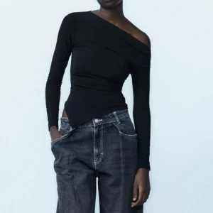 Svart oneshoulder topp - Snygg svart oneshoulder topp med lång ärm. Perfekt för en stilren look. Passar bra till både jeans och kjol.