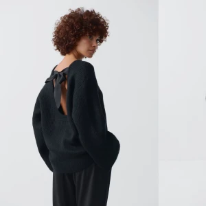 Svart tröja med öppen rygg och rosett - Snygg svart tröja med en unik design som har en öppen rygg och en dekorativ rosett. Säljer för att jag inte kan returnera. Prislappen är på 