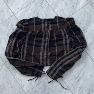 Fin blus - Jättefin blus i lila mönster. Längst ner vid vardera armslut så finns det band som man kan dra åt så att tröjärmarna blir med ”puffig”, se sista bilden. Skriv för bild på! 