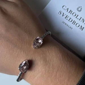 Caroline Svedbom armband  - Säljer det här fina Caroline svedbom armbandet, i silver med rosa stenar. Det är i mycket fint skick, syns bara lite missfärgning typ på baksidan, men det är inget som syns när man har på sig det! (Syns på sista bilden) ❤️ Har tyvärr tappat bort den stora asken på bilden, men kan skicka i en annan Caroline Svedbom ask som egentligen är till ringen 🙈💓