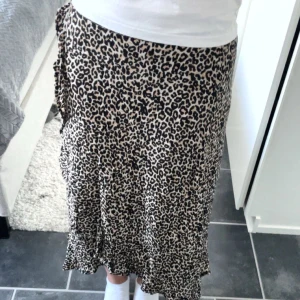 Leopardmönstrad kjol - Snygg leopardmönstrad långkjol med volangdetaljer. Perfekt för att ge en trendig touch till din outfit. Kjolen har en lös passform och är bekväm att bära.