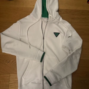  Bottega Veneta zip - Säljer en stilren vit hoodie från Bottega Veneta med grönt foder i huvan och en dragkedja framtill. Tröjan har en diskret logga på bröstet och är tillverkad i bomull. Storlek S. Självklart äkta! Skriv för mer info!