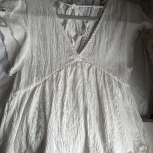 Vit sommar topp med v-ringning - Gullig vit sommar topp med  v-ringning och korta ärmar. Den har en luftig och lätt design, perfekt för varma dagar. Pris kan diskuteras, kom privat för fler bilder, den är i storlek xs/S nytt skick då den aldrig kommit till användning💕💕💕