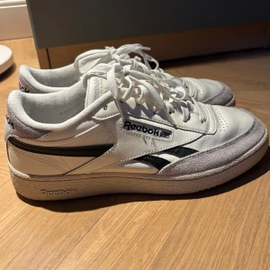 Reebok classic - Säljer ett par klassiska vita Reebok sneakers med svarta detaljer. Är i väldigt bra skick och är köpt via footlocker. 399kr  men pris kan säklart diskuteras
