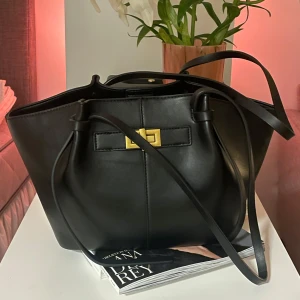 Svart axelväska med gulddetalj - Long strap mini pu väska från Gina tricot i den lilla varianten som är slutsåld(?) hittar den ej på sidan längre. Men köpte den för kanske 2 månader sedan och har knapp använt. 🖤