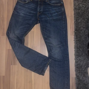 Blå jeans från Nudie Jeans - Säljer ett par klassiska jeans från Nudie Jeans. De har en normal passform med fem fickor och knappgylf. Straight fit, strl 34/34. Inga defekter! 