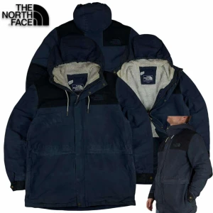 Blå jacka från The North Face - Säljer en blå jacka från The North Face med huva och broderad logga. Jackan har en mysig fleecefoder och dragsko i huvan. Perfekt för kyliga dagar. Chest 46cm. Sleeve 64cm. Length 76cm.