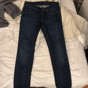 Mörkblå jeans från Tiger of Sweden - Snygga mörkblå jeans från Tiger of Sweden med klassisk femficksdesign. De har en normal passform och är perfekta för en stilren look. Märkesdetaljer syns på fickan och baksidan. Kontakta mig om ni har några frågor👍