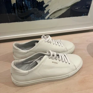 Vita sneakers från Axel Arigato - Snygga vita sneakers från Axel Arigato med stilren design. Aldrig använda! Originalpris 2200kr! 