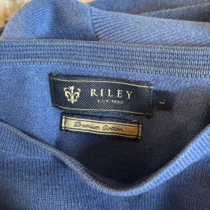 Blå tröja från Riley - Säljer en stilren blå tröja från Riley i premium bomull. Perfekt för en avslappnad look. Tröjan har en klassisk design med rund hals. Knappt använd av mig då den är för liten. Väldigt skönt material och snyggt. Köptes för 699