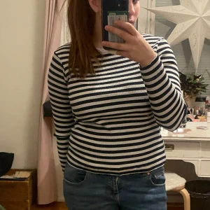 Randig tröja från H&M - Säljer en randig tröja från H&M i svart och vit. Tröjan är ribbad och har långa ärmar, perfekt för en stilren look. Passar bra till jeans eller kjol för en avslappnad stil.