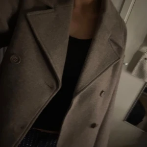 Beige kappa - Snygg beige kappa med klassisk design och knappar framtill. Perfekt för kyligare dagar och ger en stilren look. Passar bra till både vardag och mer uppklädda tillfällen.använd ca 3 gånger super fint skick! Jätte fin jacka ❤️❤️