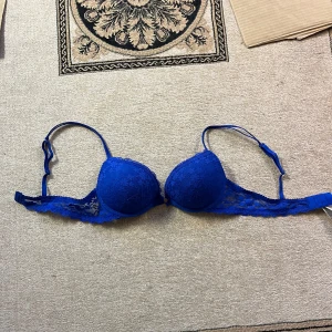Blå spets-bh - Snygg blå bh med spetsdetaljer. Den har justerbara axelband och en klassisk knäppning bak. Inte alls använd!❤️