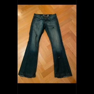 Lowwaist bootcut jeans - Snygga blå bootcut jeans med slitningar på framsidan. Lågmidjade