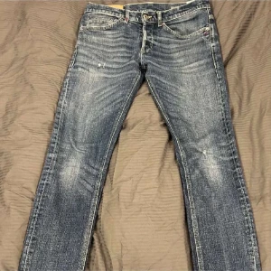 Blå jeans med broderad detalj - Snygga blå jeans med en broderad detalj på bakfickan. 