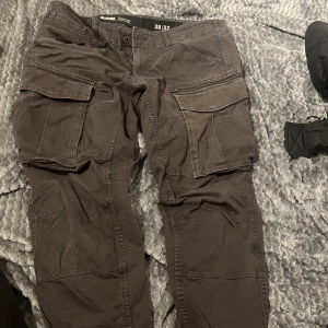 Svarta cargobyxor från G-Star RAW - Säljer ett par svarta cargobyxor från G-Star RAW. Byxorna har flera praktiska fickor och en dragkedja. Perfekta för en avslappnad stil med en loose passform. Dem är använda men i jätte bra skick! 