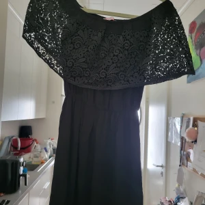 Svart långklänning med spetsdetaljer från Doma Bella - Säljer en elegant svart långklänning från Doma Bella. Klänningen har vackra spetsdetaljer upptill och är perfekt för festliga tillfällen. Den är i storlek S/M och har en normal passform. Klänningen är i nyskick och redo att bäras på nästa stora event!