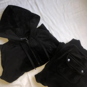 Svart juicy couture set - Svarta juicy couture set för 900kr byxorna är i storlek S och koftan är XS. Använt många gånger, tyget på ena knät är inte lika mjukt som förut tror det är för jag stått på knä eller nått (skriv för bild) men allt annat är i bra skick🖤