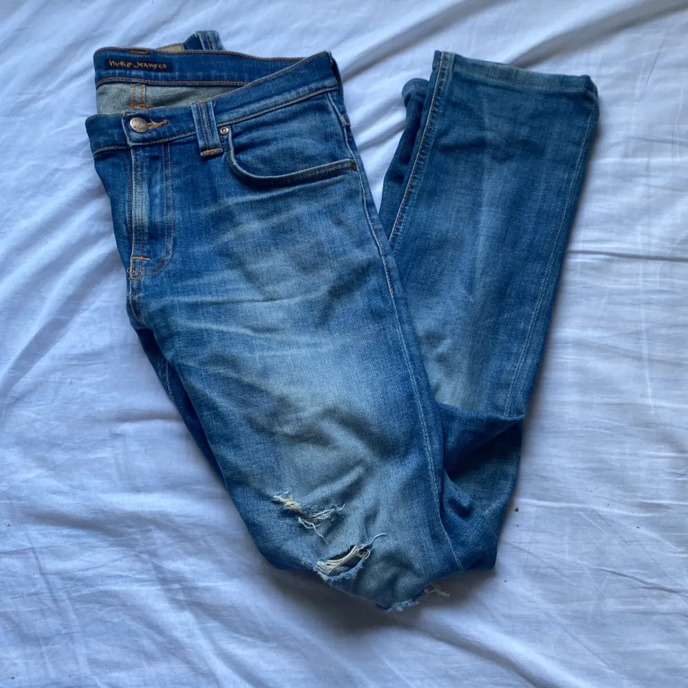 Ett par riktigt feta nudie jeans med snygga slitningar som nu säljs! Skick:9/10 inga defekter, knappt använda. Ny pris:1600kr Stl: 29W,32L. Jeans & Byxor.