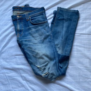 Nudie Jeans - Ett par riktigt feta nudie jeans med snygga slitningar som nu säljs! Skick:9/10 inga defekter, knappt använda. Ny pris:1600kr Stl: 29W,32L