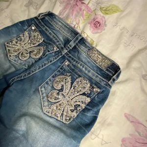 Blå jeans med broderade bakfickor - säljer nu mina miss me jeans då dem inte sitter så bra på mig, jag har själv sytt om dom som ni ser på bilder, går tyvärr inte lägre än 500kr. dem har super fina mönster på fickorna och diamant knappar. lågmidjade och flared 