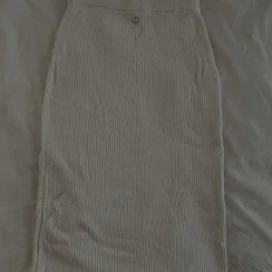 Ribbad Guess kjol - Vit ribbad guess kjol! Går ner under knäna men går att justera vid sidan!🤍 Pris ej inkl. frakt, kan även mötas upp i Stockholm! 