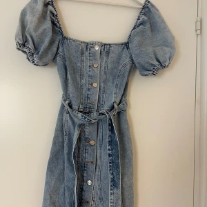 Jeansklänning - Jeansklänning med knappar och knytning