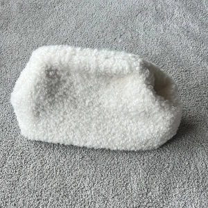 Clutch väska - Sthlm LM MQ clutch väska i Teddy material. Nyckick och endast använd en gång. Säljer då den inte kommer till användning🥰