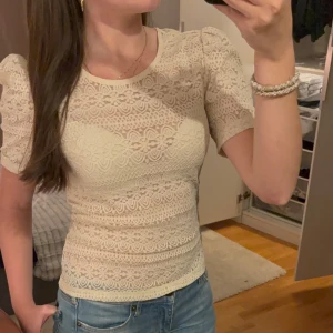 Beige spetsblus från VILA - Säljer en superfin beige spetsblus från VILA i storlek S. Blusen har korta ärmar och ett vackert spetsmönster som ger en romantisk känsla. Perfekt för både vardag och fest! 💫