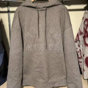 Maison Kitsuné - Riktigt fet grå hoodie i ny skick. Passar storlek S, men sitter lite större. Annars väldigt bra passform och passar till de mesta. Skriv vid frågor eller funderingar! Köpt på Vestiaire!!