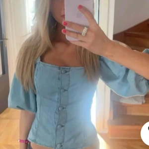 Ljusblå jeansblus med puffärmar💖💖 - Säljer en superfin ljusblå jeansblus med puffiga trekvartsärmar och knappar! Blusen har en söt och trendig stil som passar både till vardags och fest. Den är i bra skick och redo för nya äventyr! 💙LÅNAD BILD💖