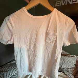 Vit t-shirt från Zara - Säljer en enkel och stilren vit t-shirt från Zara i storlek S. Den har en liten bröstficka som ger en snygg detalj. Perfekt för vardagsbruk och kan matchas med nästan vad som helst. T-shirten är i bomull och känns skön mot huden.