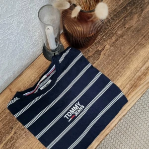 Randig t-shirt från Tommy Jeans - Säljer en snygg randig t-shirt från Tommy Hilfiger i marinblått och vitt. Den har en relaxed fit.