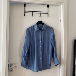 Blå skjorta från H&M - Säljer en snygg blå skjorta från H&M i storlek S. Skjortan har långa ärmar och knappar hela vägen ner. Perfekt för både vardag och fest! 💙