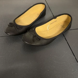 Ballerina skor - Väldigt bra sick. Storlek 37. Skorna är svarta med en rosett.