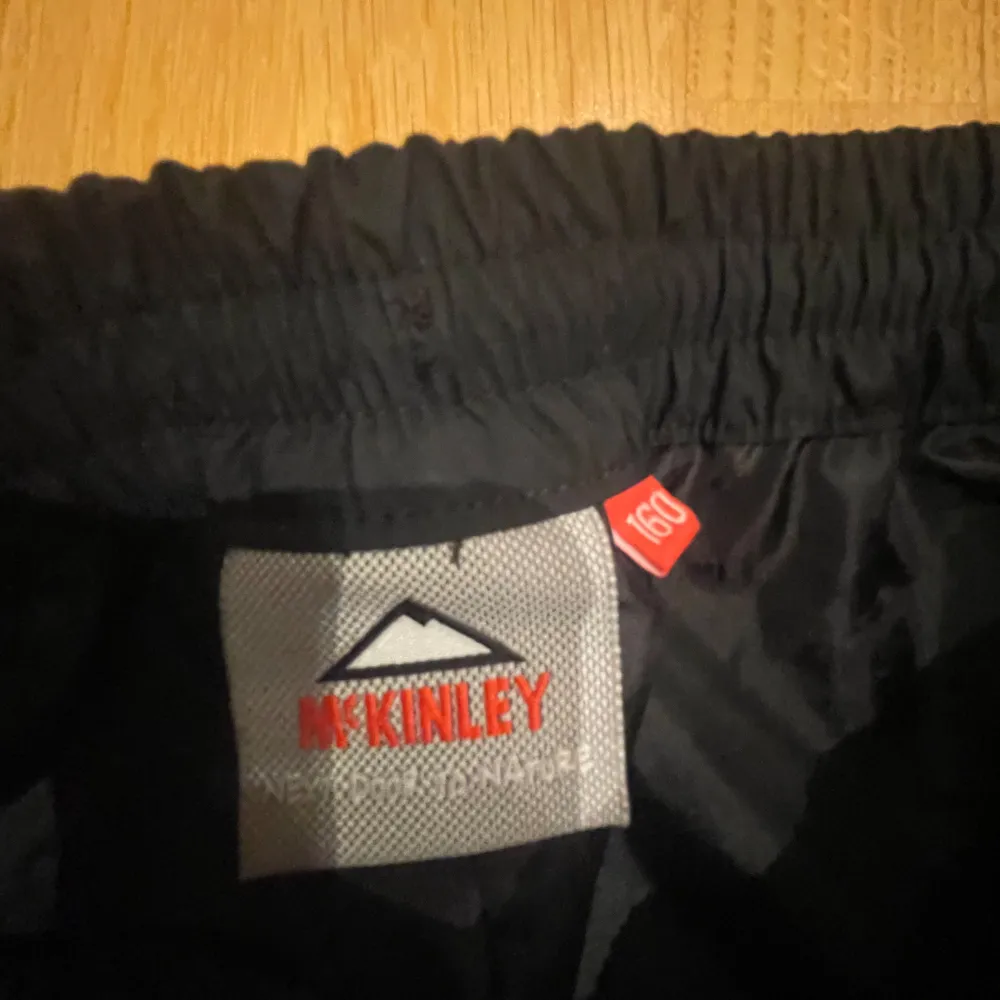 Säljer ett par svarta byxor från McKinley. De har en elastisk midja för extra komfort och är perfekta för utomhusaktiviteter. Byxorna är i bra skick och redo för nya äventyr! (Regn byxor). Farkut & Housut.