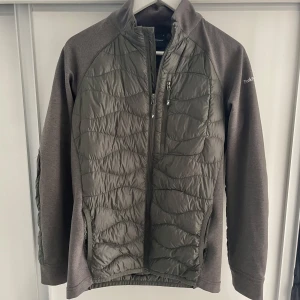  Peak Performance cardigan. - Peak performance av modellen HELIUM DOWN HYBRID JACKET. Färgen är olivgrön och i bra skick. Tröjan/jackan är delvis fylld med dun. Nypris 2500kr