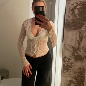 Vit topp ifrån Nelly  - En jätte snygg vit spets topp ifrån Nelly i storlek XS men passar mig som bär storlek S och är 172 cm lång! Enbart använd en gång och råka fastna med ett armband :( därav sista bilden litet hål i tröjan men man tänker inte på de, sen kan man även sy in de men har varit lite lat 🤣Jätte snyggt att ha ett linne under toppen också!! 