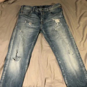 Snygga Jeans från replay - Sjukt snygga ljusblå jeans från Replay med slitna detaljer för en trendig look. Storlek W30 L32