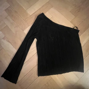Fest topp - Snygg svart oneshoulder topp med lång arm.