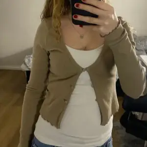 Beige tröja från HM i storlek XS med tre knappar och fina detaljer i ärmar och nertill.
