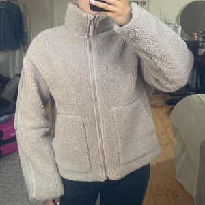 Beige teddyjacka med dragkedja - Mysig beige teddyjacka med dragkedja framtill. Jackan har en hög krage och två stora fickor. Perfekt för kyliga dagar när du vill hålla dig varm och bekväm. Den är ifrån barnavdelningen på hm och är i storlek 158/164 passar mig bra som är s/m på jackor🌸