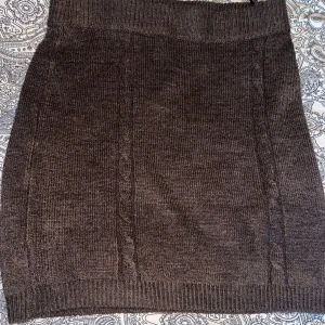 Brun stickad kjol från Gina Tricot - Snygg brun stickad kjol från Gina Tricot. Kjolen har en ribbad midja och subtila kabelstickade detaljer som ger en stilren look💋🙌🏼Kjolen är använd men i väldigt fint skick🙂🙂Defekten jag kan komma på är att den är nopprig på baksidan, jag har försökt få bort de mesta! Se sista bilden för defekten i sådana fall 🥰Står st M men tycker att den passar S också😍